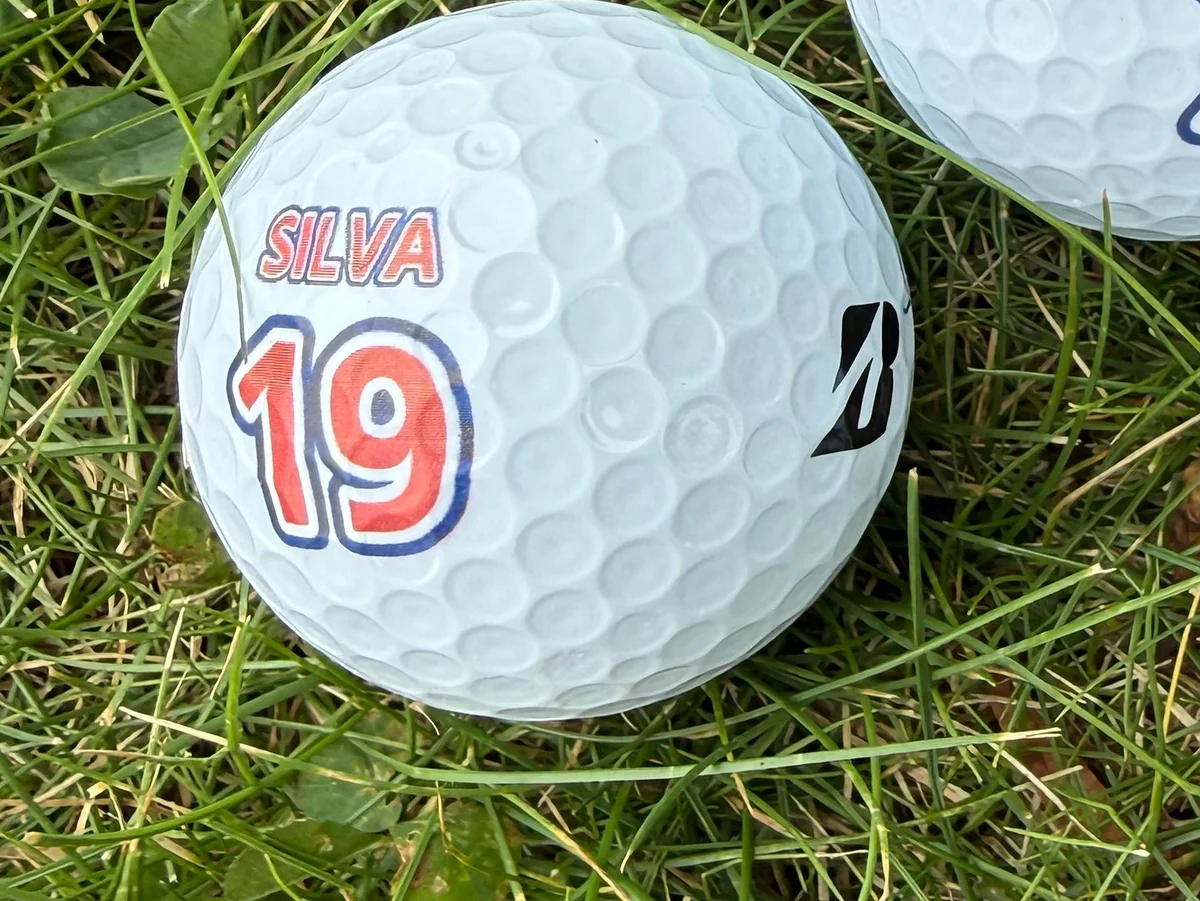 Golfpallo pelaajan nimellä ja numerolla